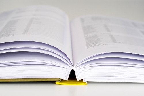 Livre ouvert illustrant les rapports financiers et documents réglementaires publiés par HERIGE Industries